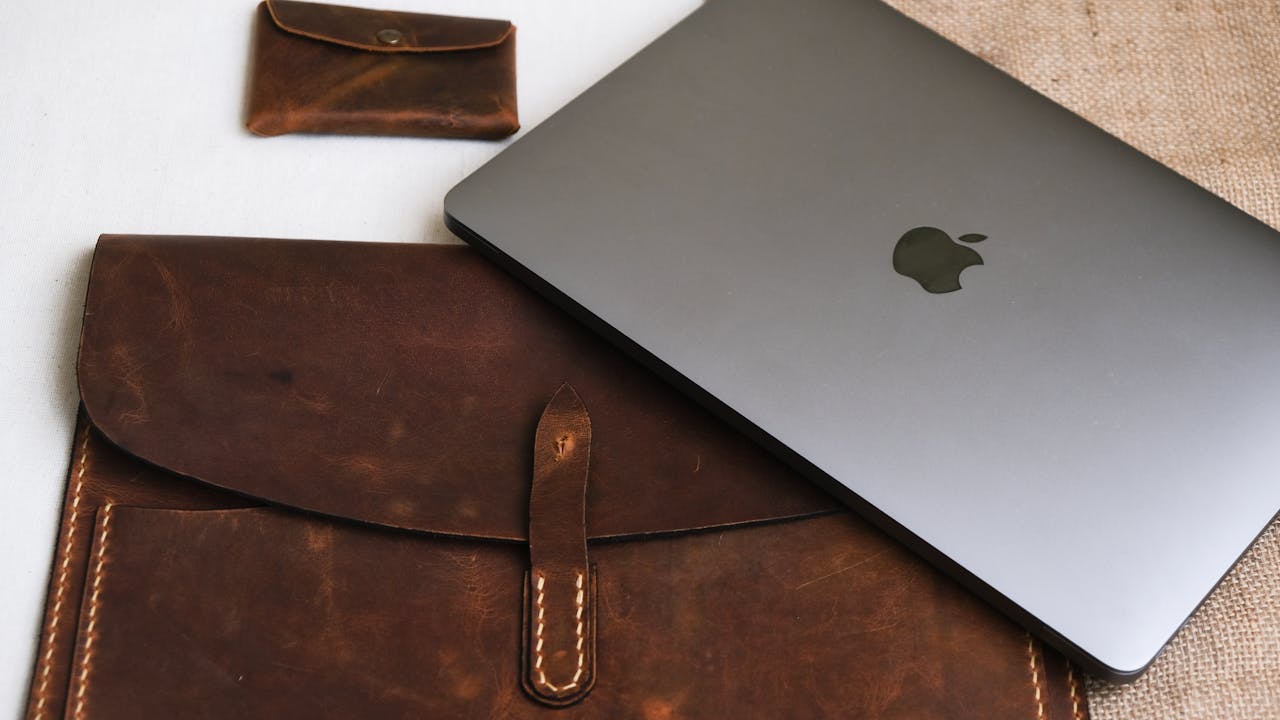 gallery-4 A sleek laptop with leather sleeve and pouch, perfect for stylish professionals.